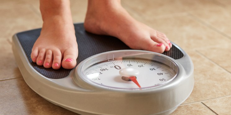 woman weighing herself on a scale