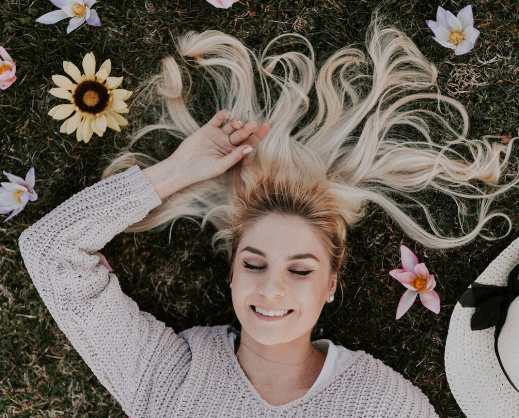 smiling woman laying on flowers