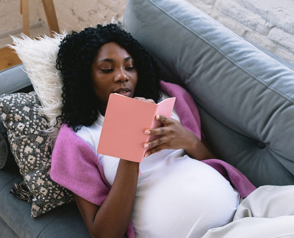 pregnant Black woman writing in notebook