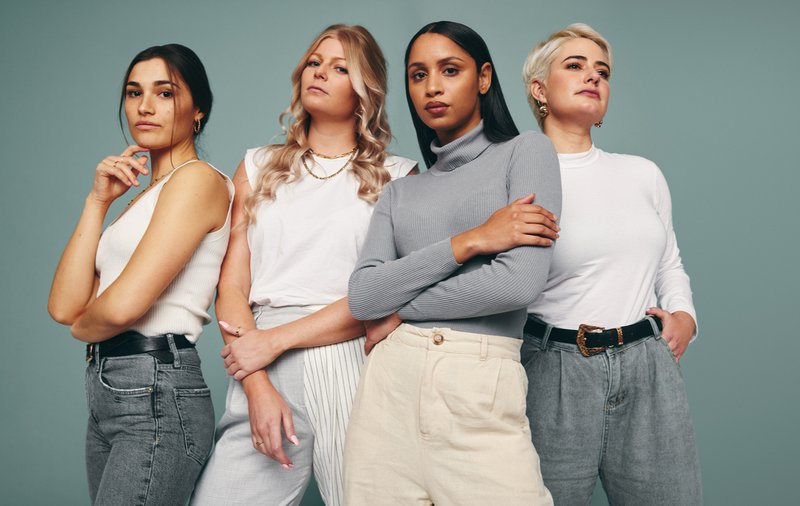 Style and confidence. Diverse group of empowered women standing together against a studio background. Self-confident female friends standing in a studio.